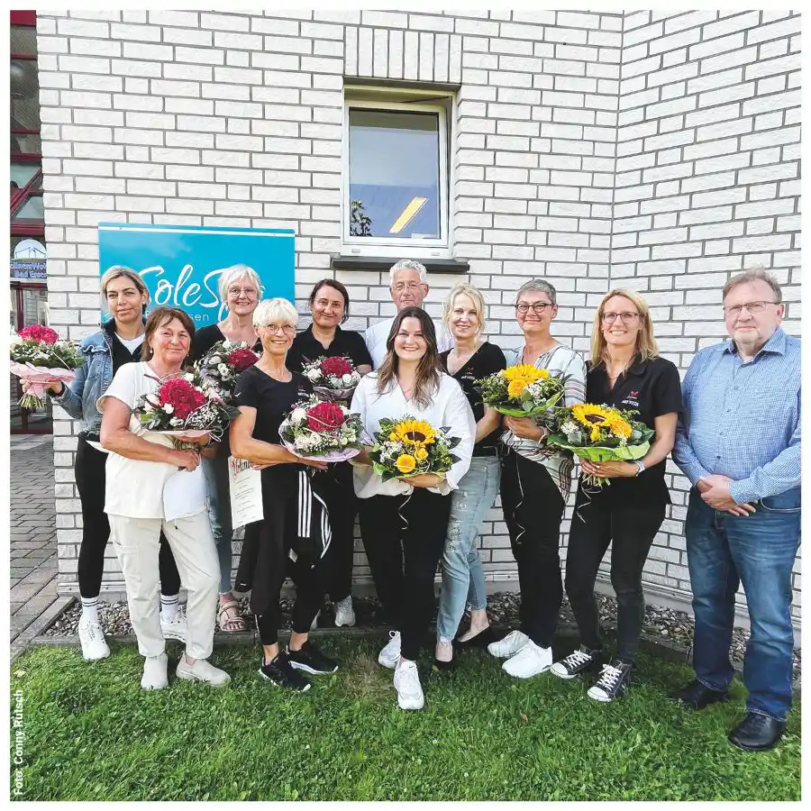 Gruppenfoto der Osteoporose-Selbsthilfegruppe Bad Essen mit Blumensträußen und Urkunden.