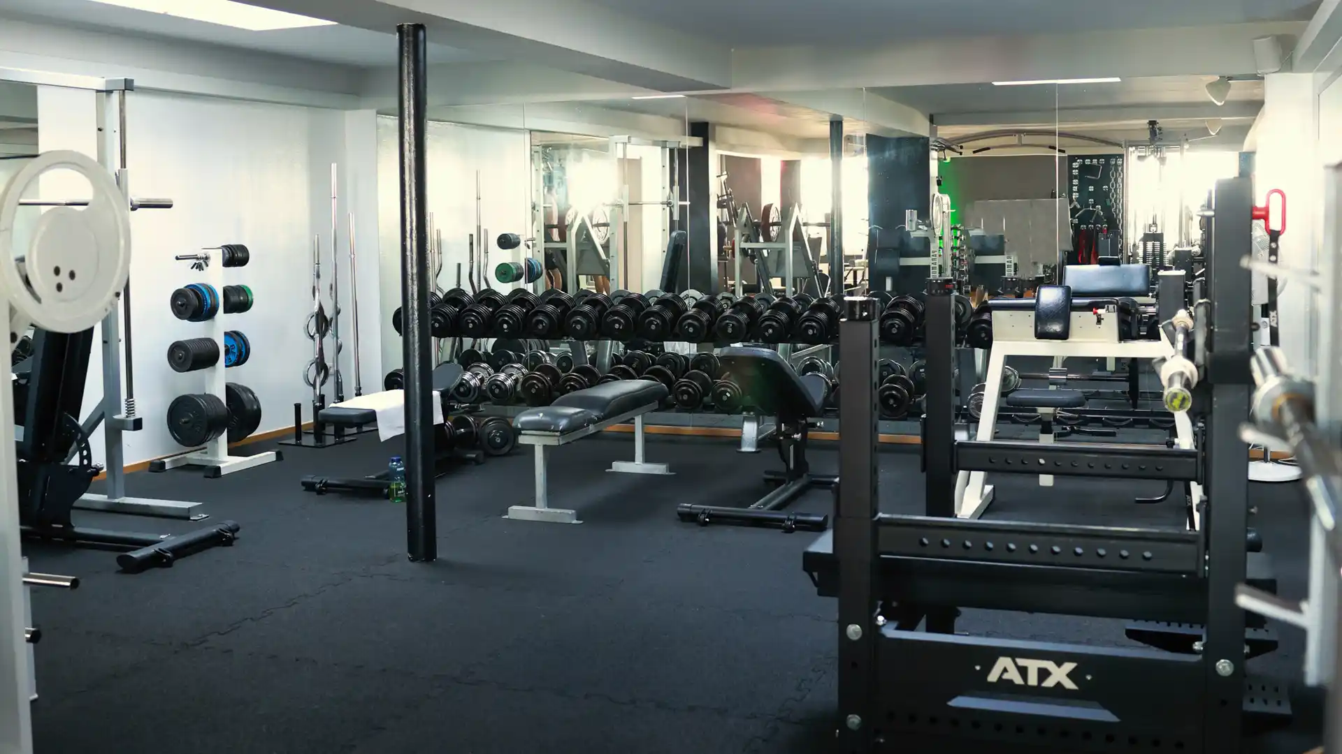 Krafttrainingsbereich im AKTIVITA B.E. GYM Moderne Krafttrainingsfläche im AKTIVITA B.E. GYM mit Hantelbänken, Gewichten und Freihantelbereich.