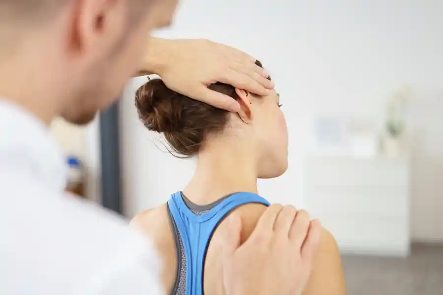 Therapeut behandelt Patientin im Bereich der Halswirbelsäule.