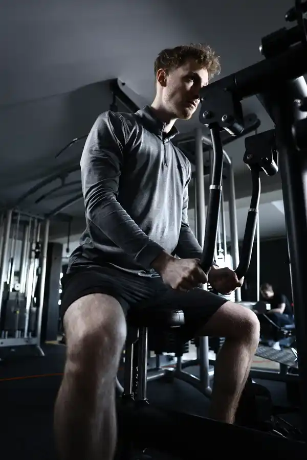 Bein- und Rumpfmuskulatur Training Mann sitzt an Gerät im AKTIVITA B.E. GYM und trainiert Bein- und Rumpfmuskulatur.